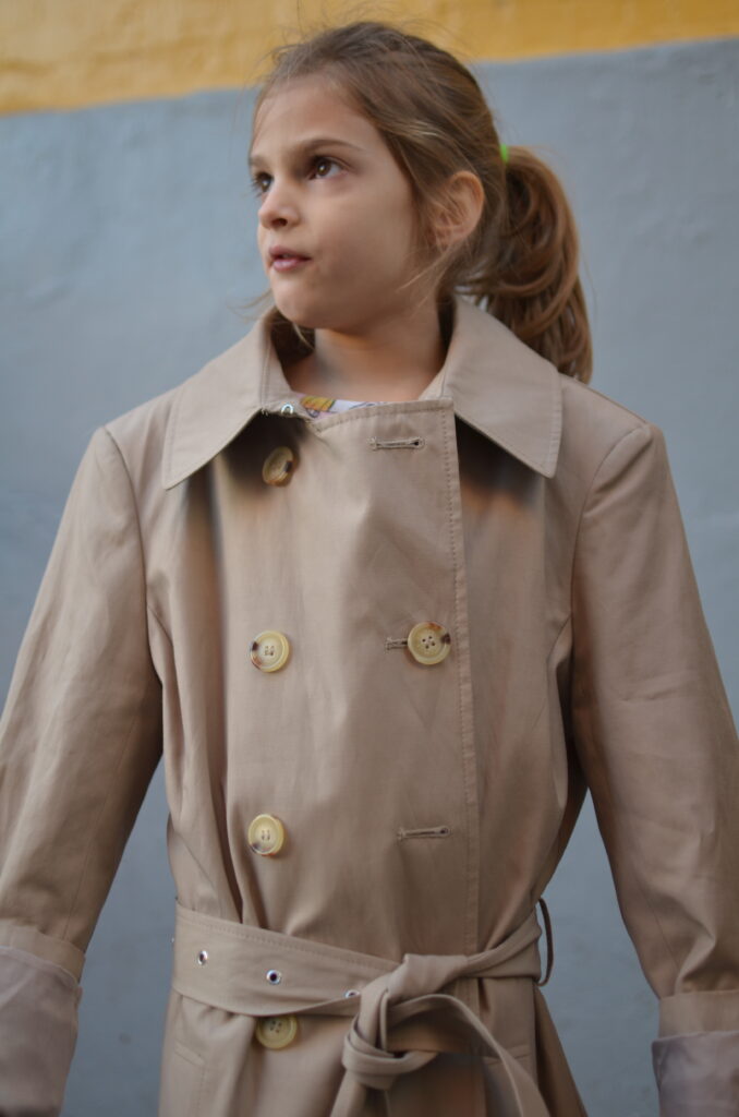 Young girl wears her mom's oversized coat